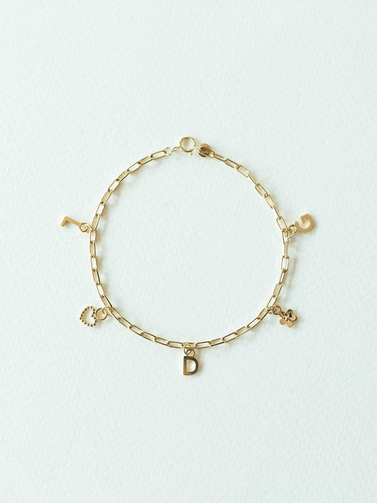 Choose your charms bracelet featuring 5 pendants in solid gold on a white background