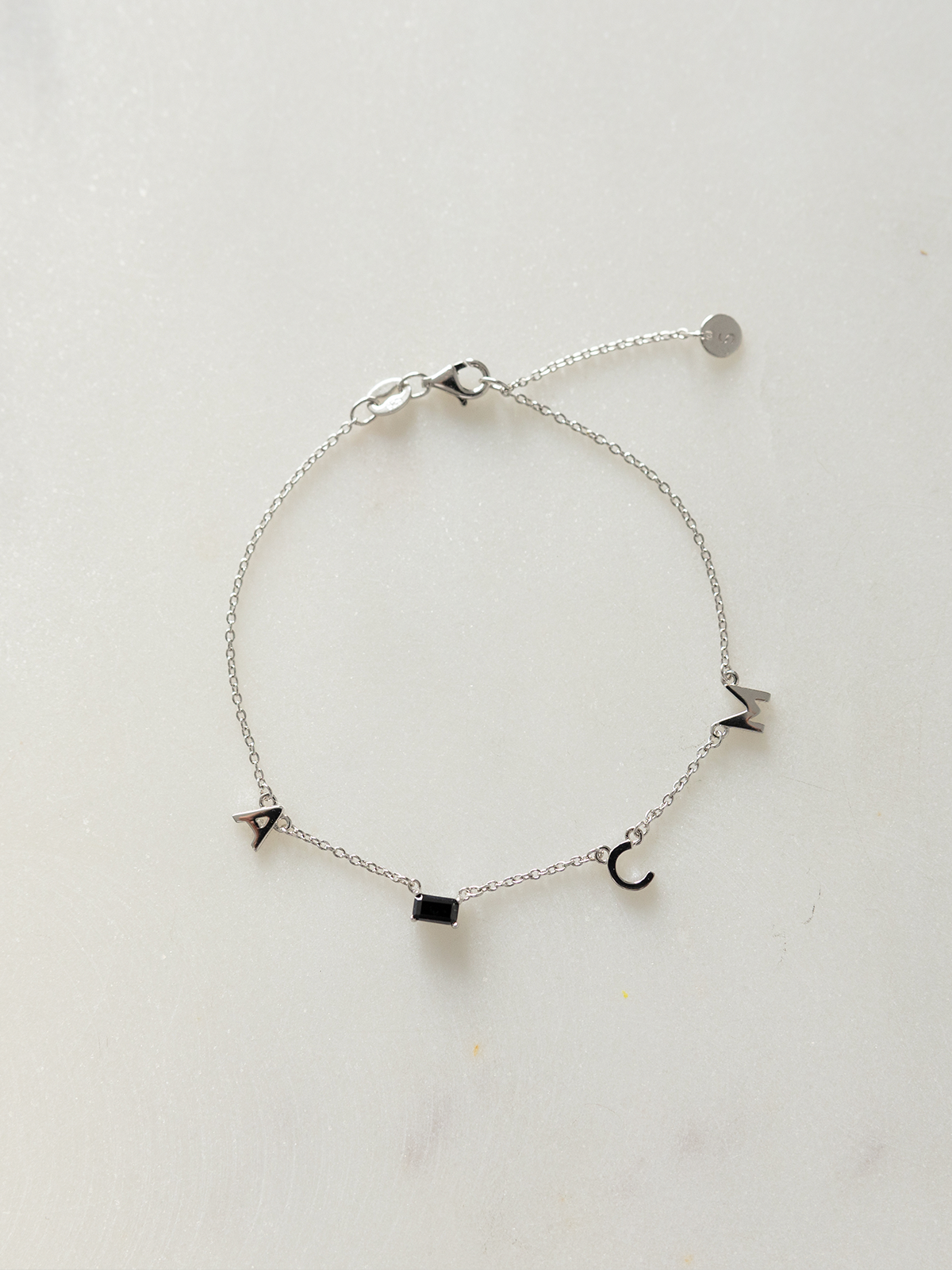 Silver choose your letters bracelet on a light gray background
