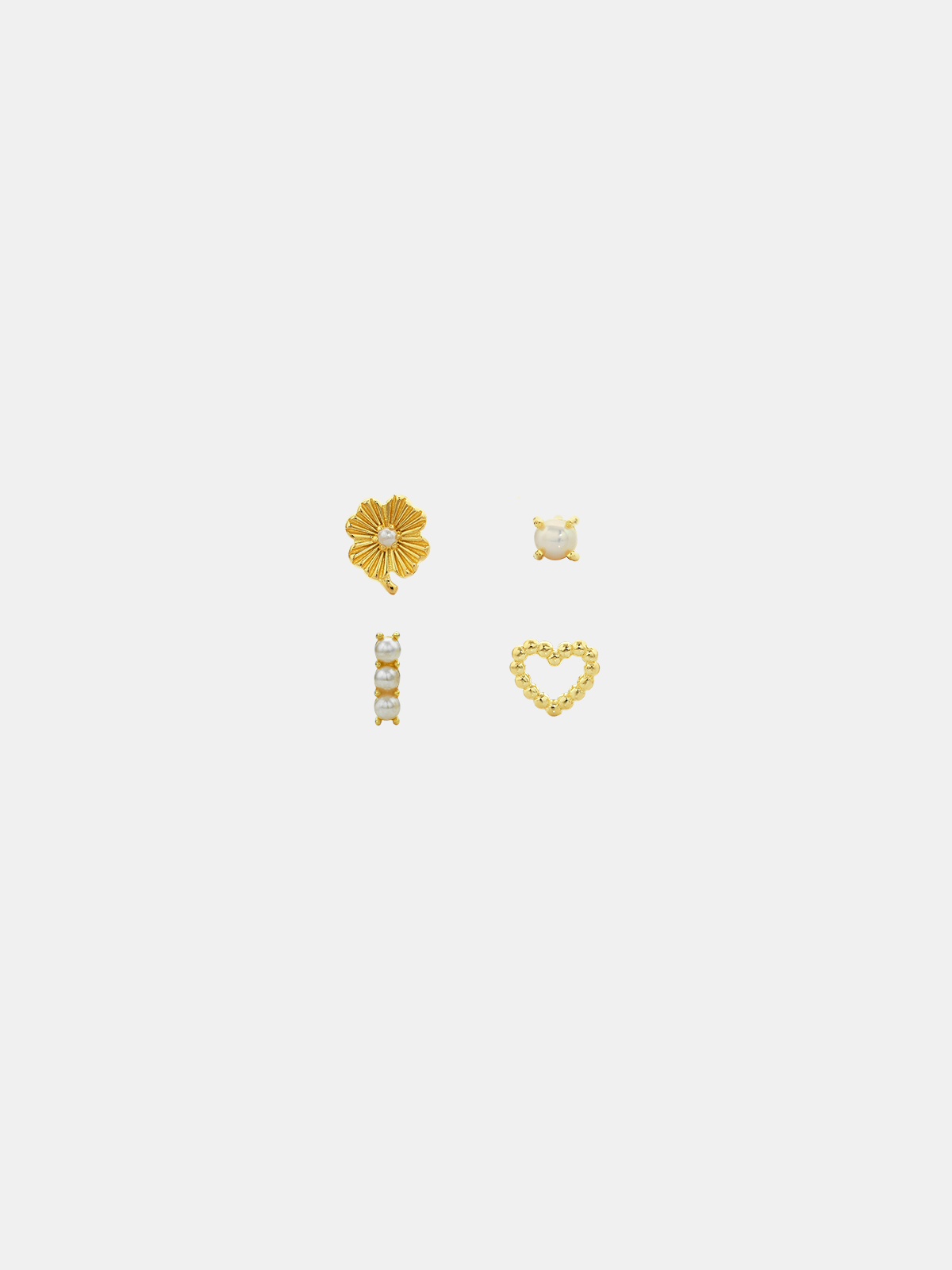 Four gold earrings on a white background