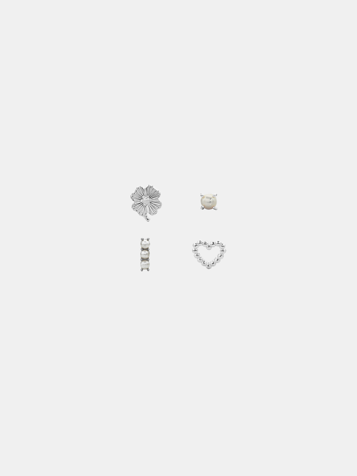 Set of four silver earrings on a light gray background