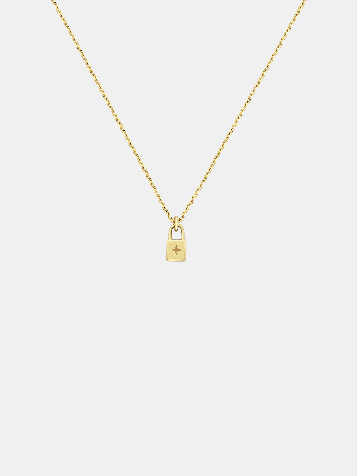 Solid gold necklace with a small padlock pendant on a light gray background