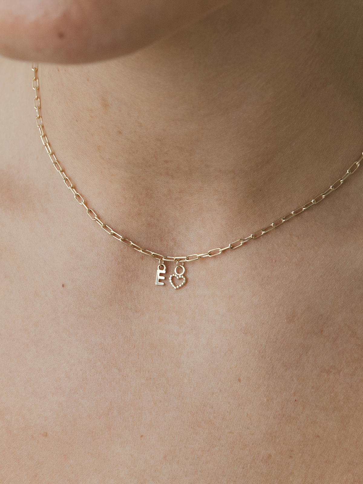 Gold necklace with charms on a person's neck