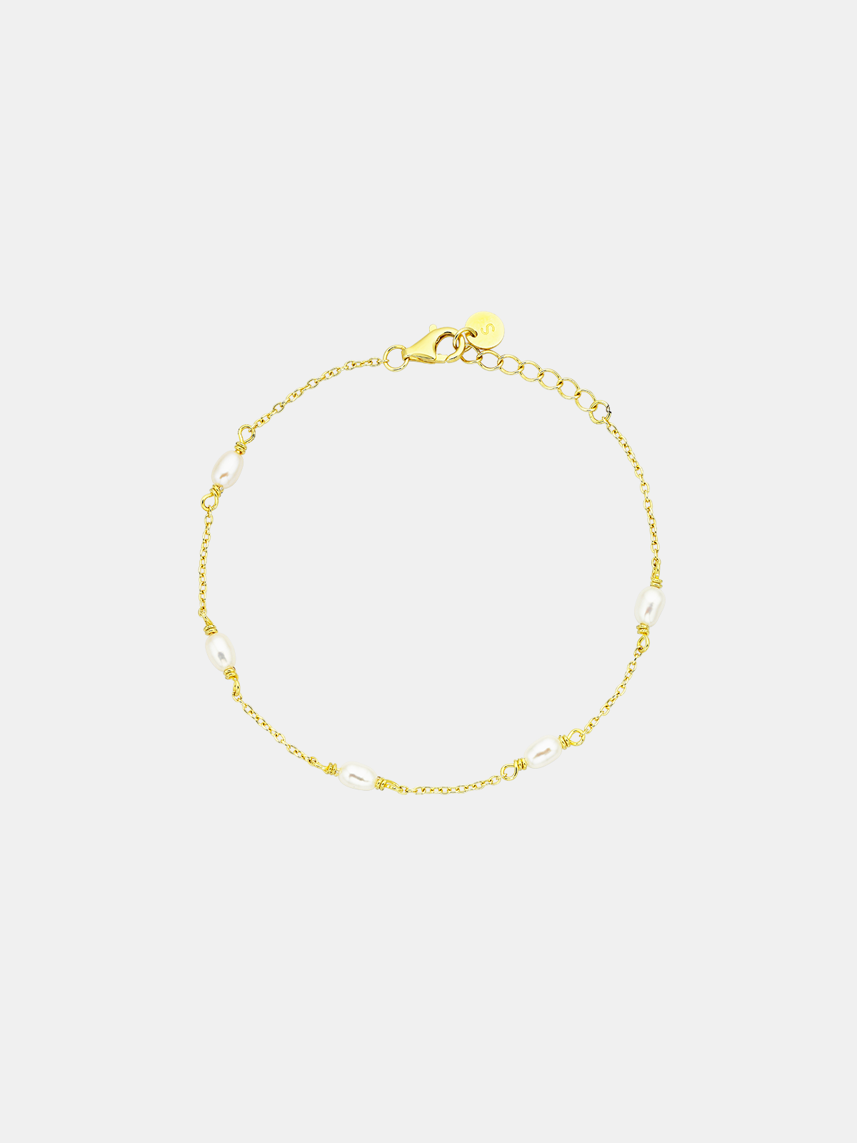 Gold bracelet on a light gray background