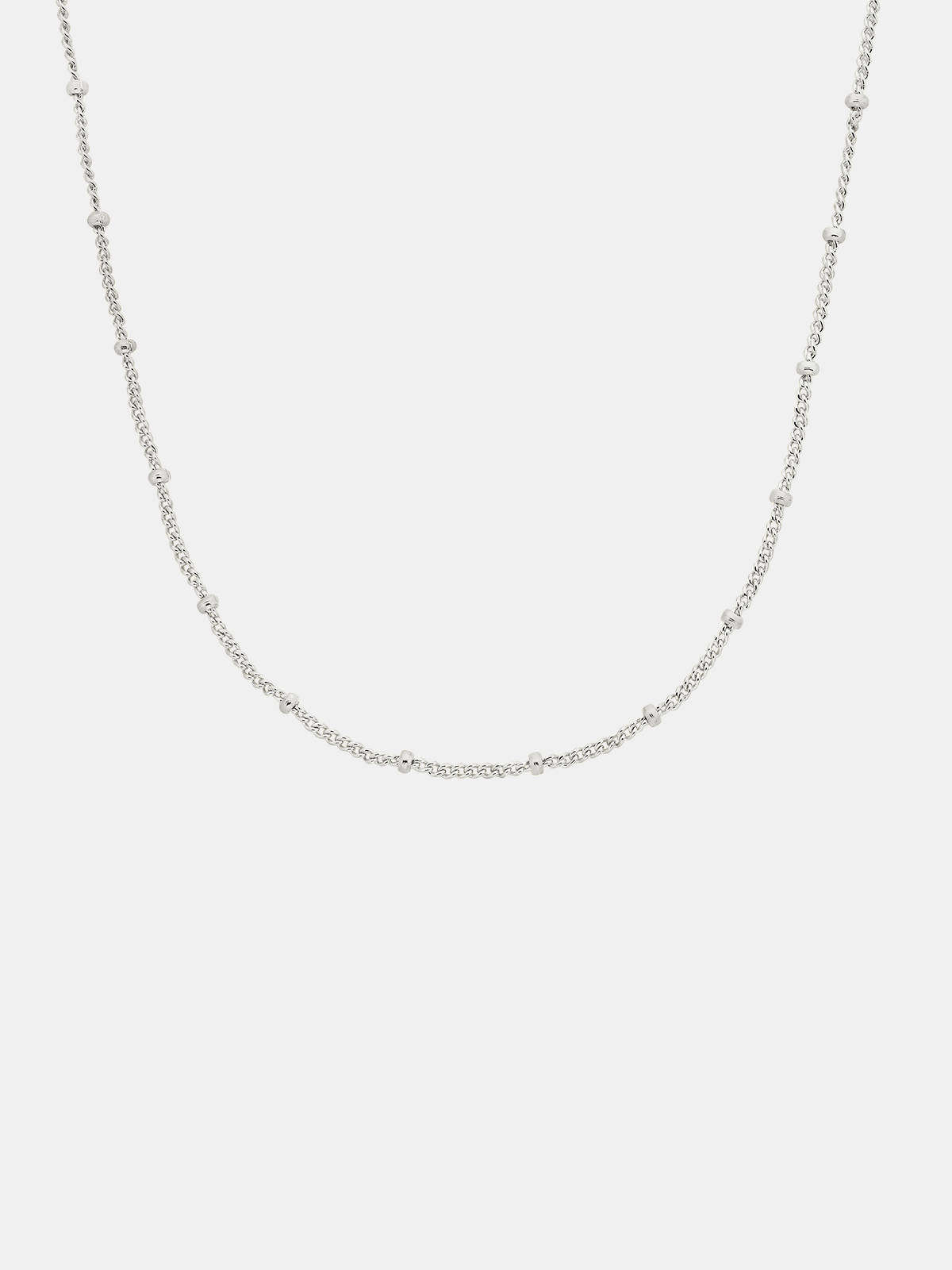 Silver chain necklace on a light gray background