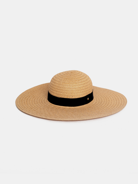 Straw hat with a black band on a light beige background