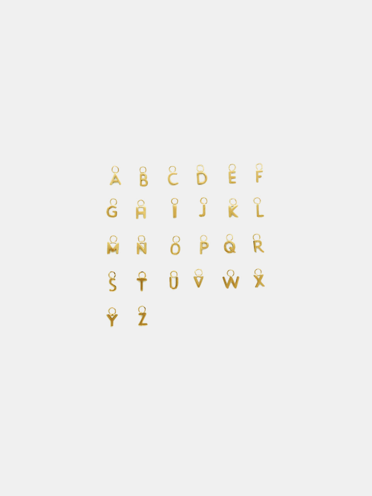 Solid gold little letter pendants on a white background