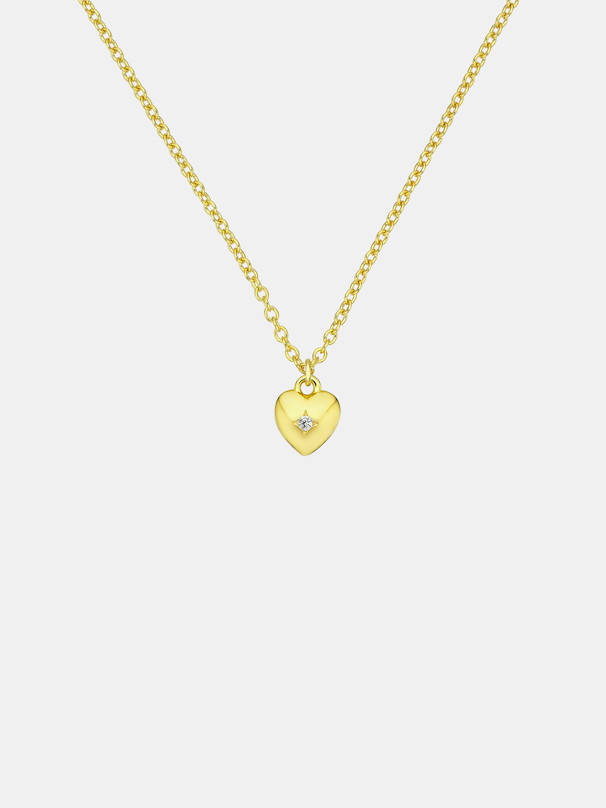 Gold heart-shaped pendant necklace on a light gray background