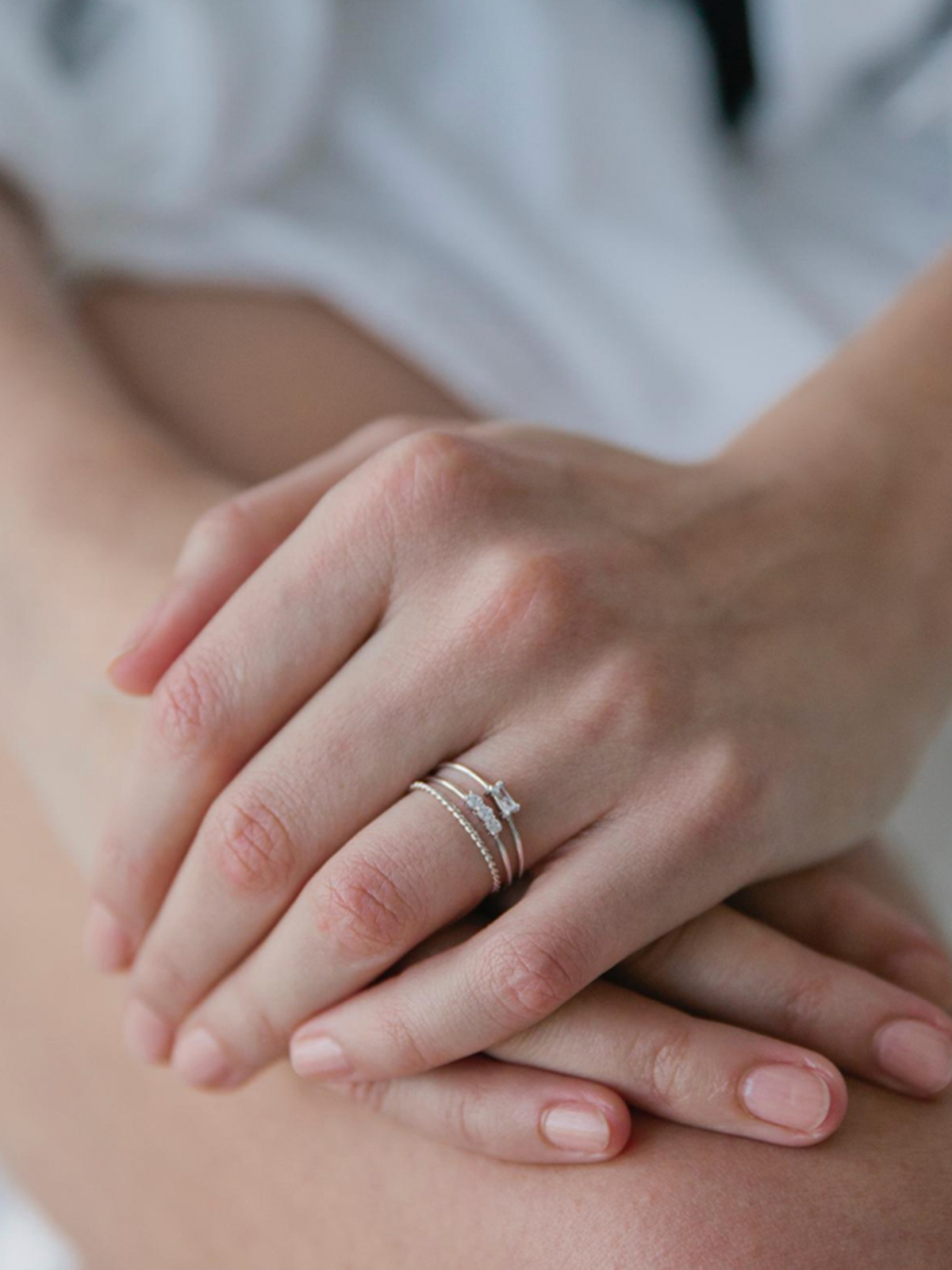 Close-up of hands with a ring stack on a blurred background
