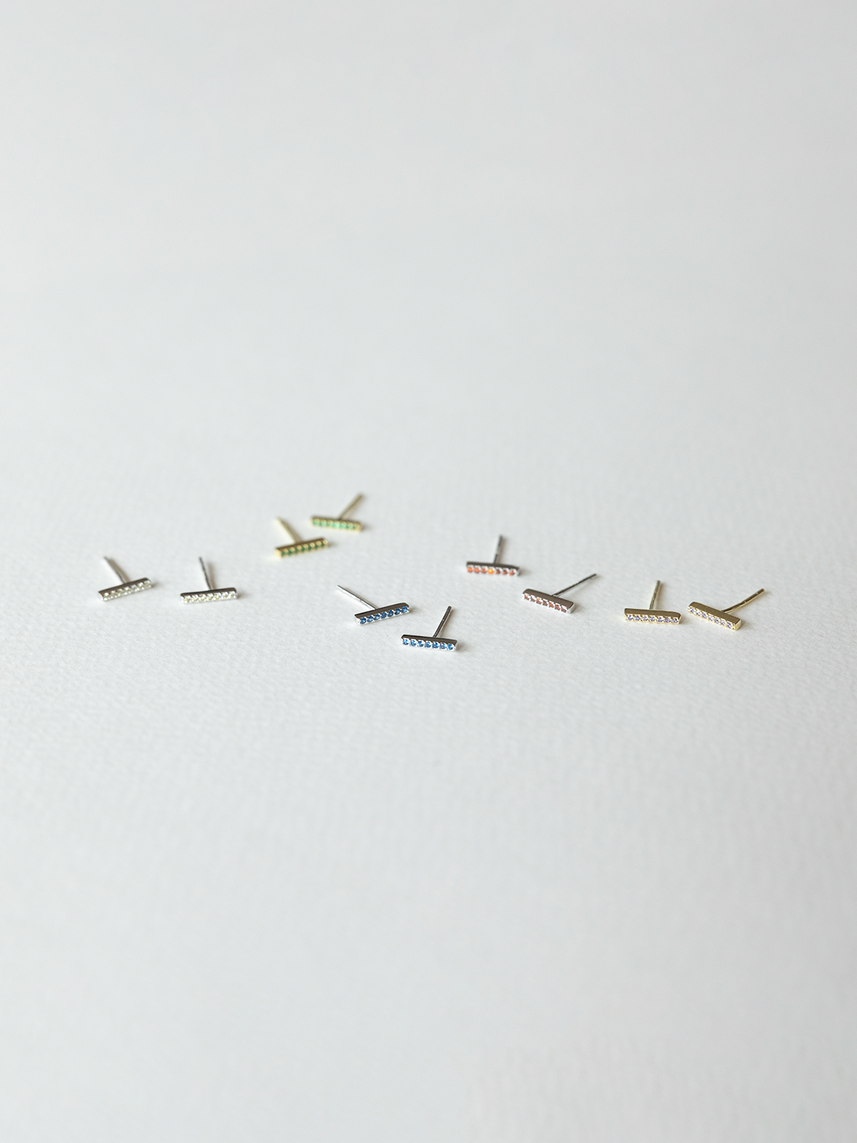 Small birthstone earrings laid out on a white background