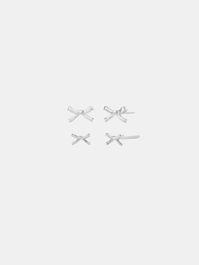 Set of four silver bow-shaped earrings on a light grey background