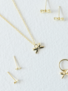 Gold jewelry set including necklace, earrings, and pendants on a white background