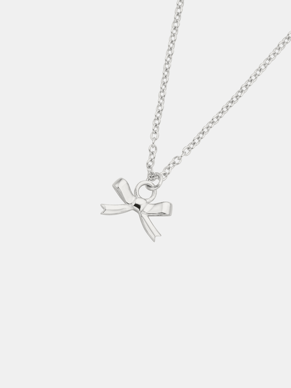 Silver necklace with a bow pendant on a white background