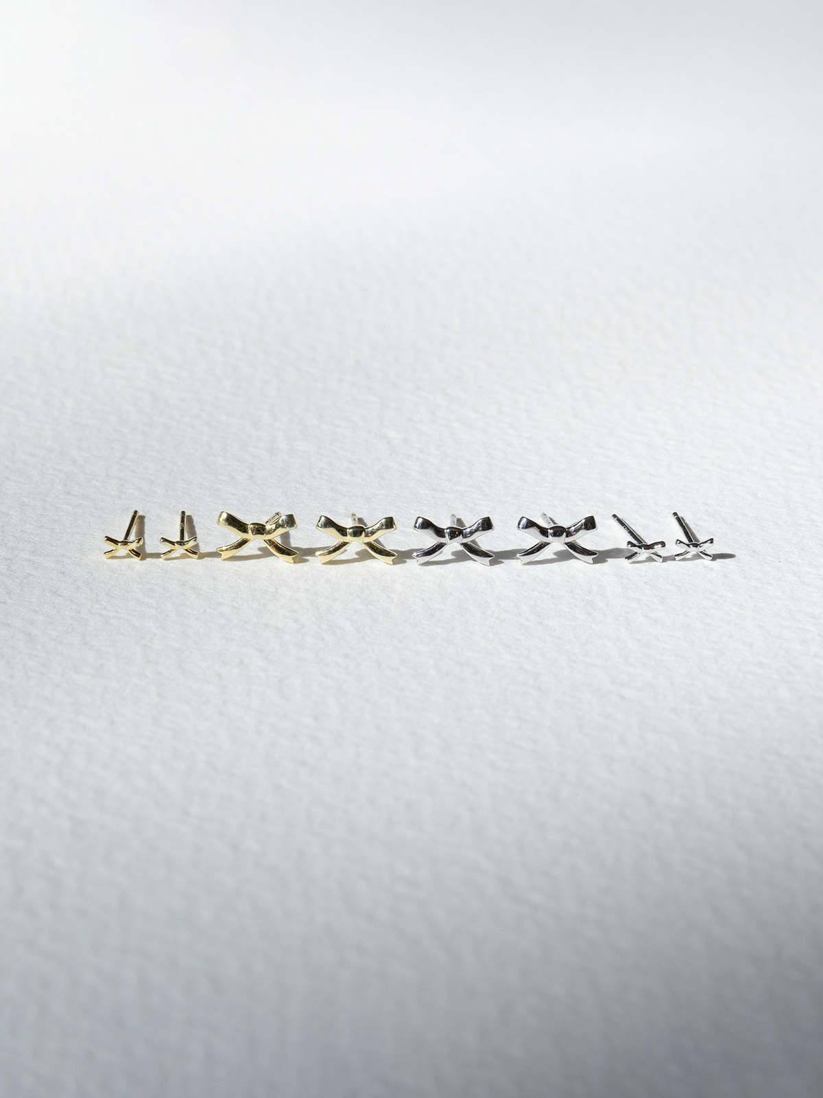 Set of gold and silver earrings on a light grey background