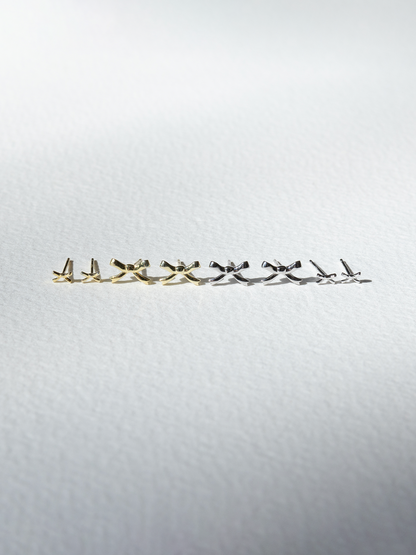 Set of gold and silver earrings on a light grey background