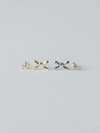 Pair of gold and silver bow-shaped earrings on a light gray background