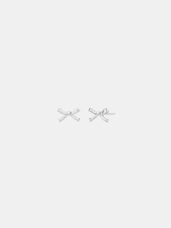 Pair of silver bow-shaped earrings on a light gray background