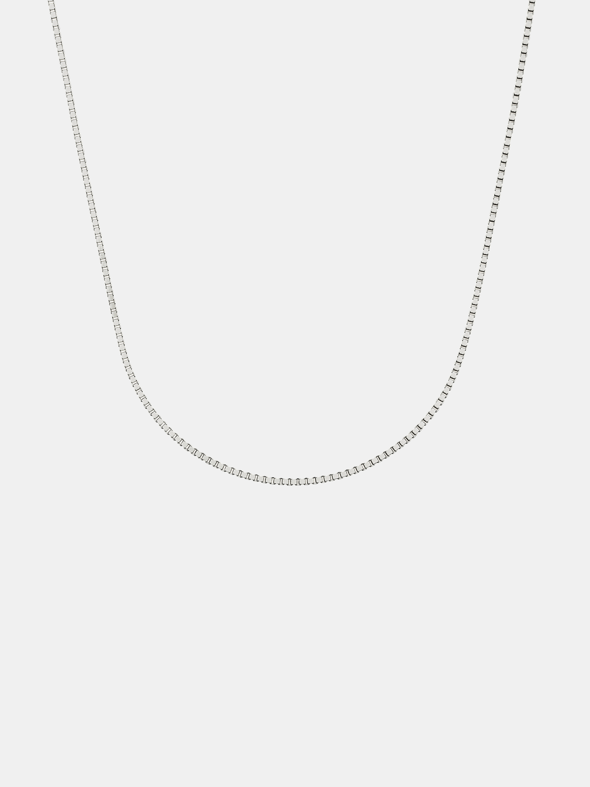 Silver box chain necklace on a light gray background