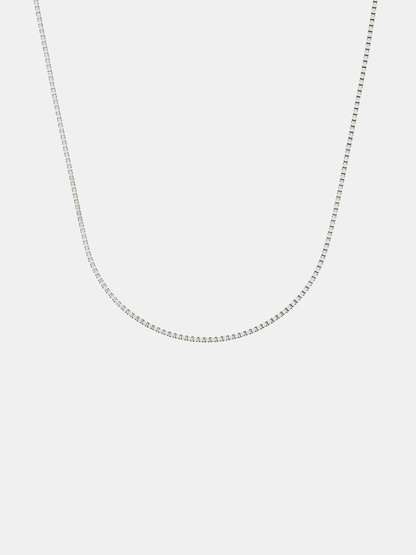 Silver box chain necklace on a light gray background