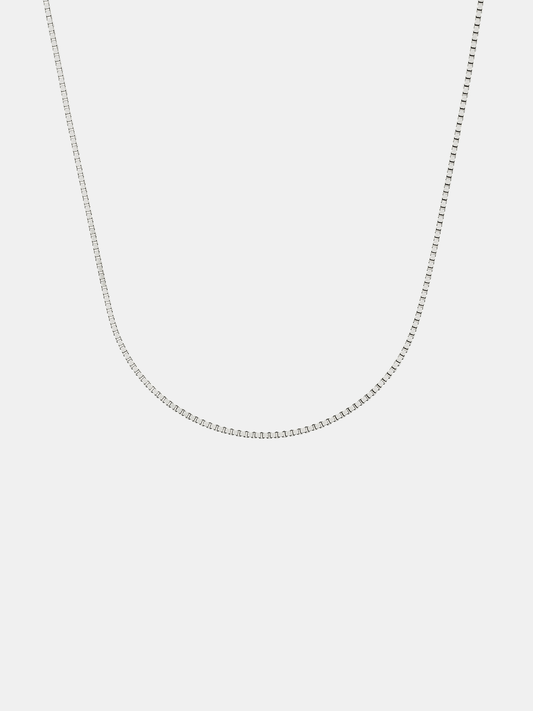 Silver box chain necklace on a light gray background