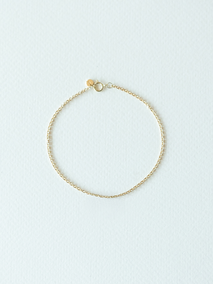 Gold bracelet on a light blue background