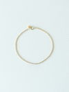 Gold bracelet on a light blue background