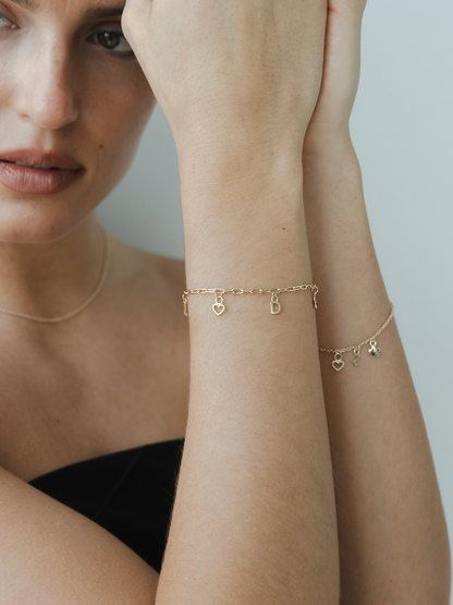 Woman wearing gold bracelets on a neutral background