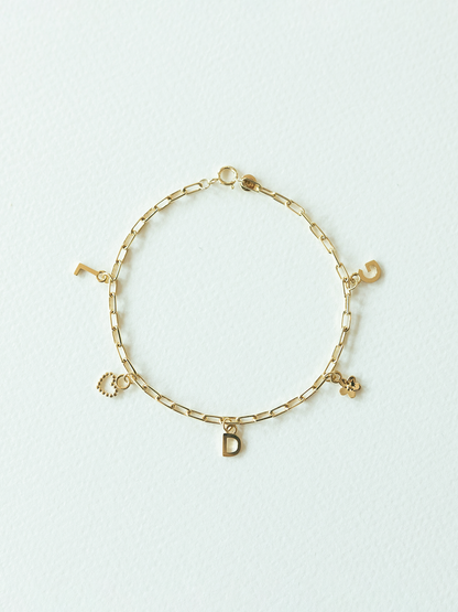 Choose your charms bracelet featuring 5 pendants in solid gold on a white background