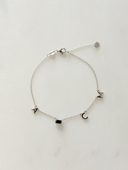 Silver choose your letters bracelet on a light gray background