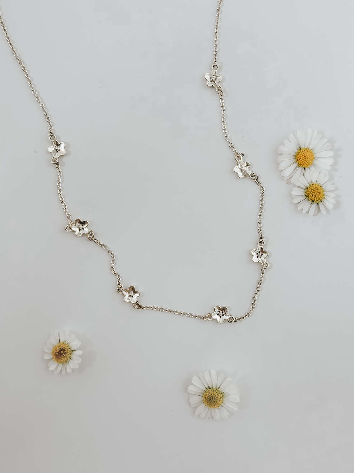 Necklace with floral pendants on a light gray background