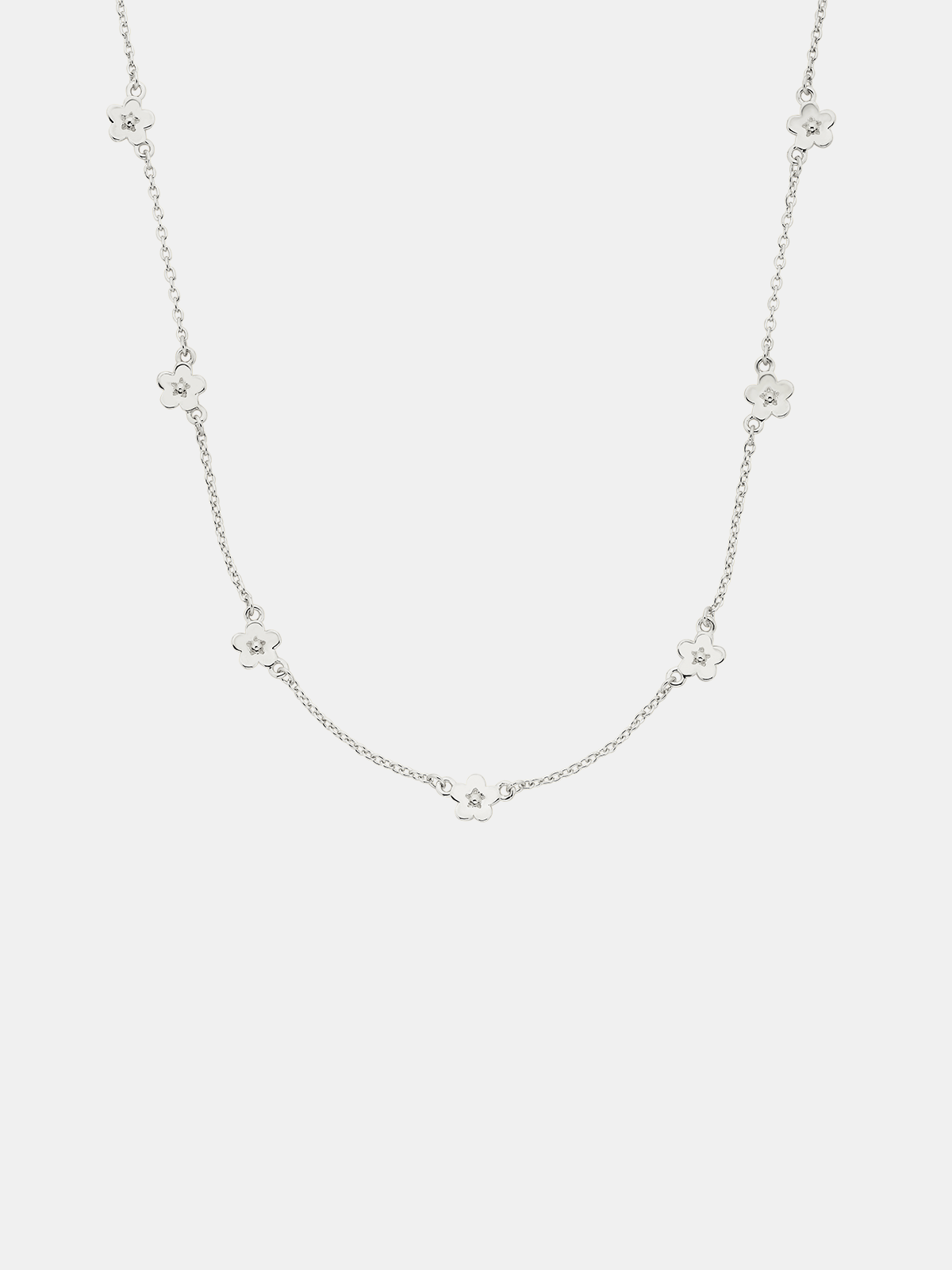 Silver necklace with small floral pendants on a white background