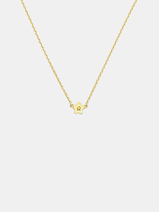 Solid gold necklace with a small daisy day flower pendant on a light grey background