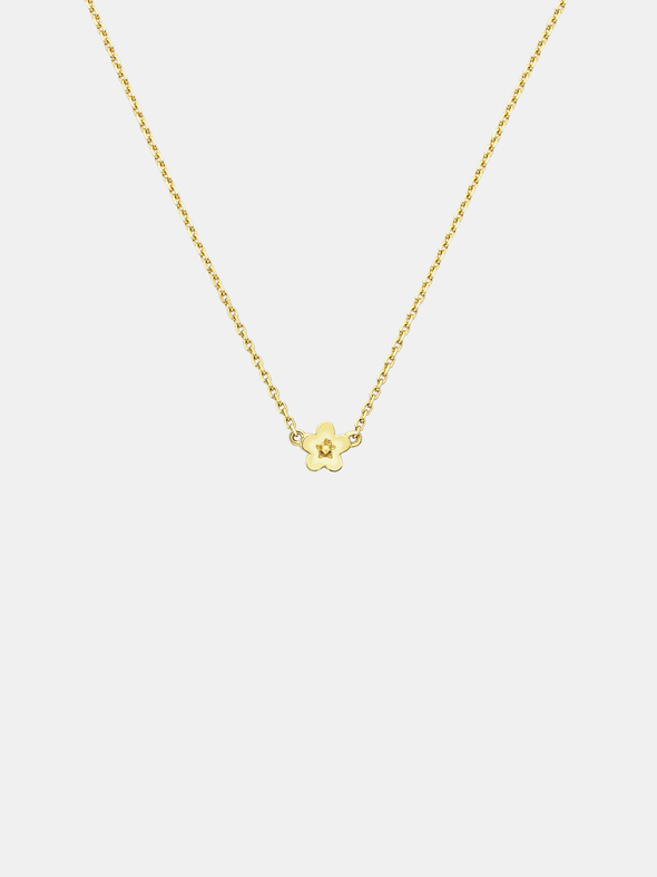 Solid gold necklace with a small daisy day flower pendant on a light grey background
