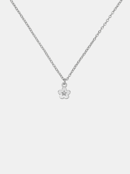 Silver necklace with a small flower pendant on a light gray background