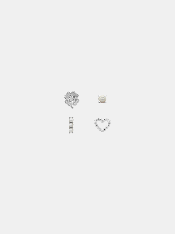 Set of four silver earrings on a light gray background