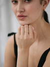 Close-up of a woman wearing a gold ring on her finger with a blurred background