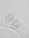 A gold and silver lines ring in water