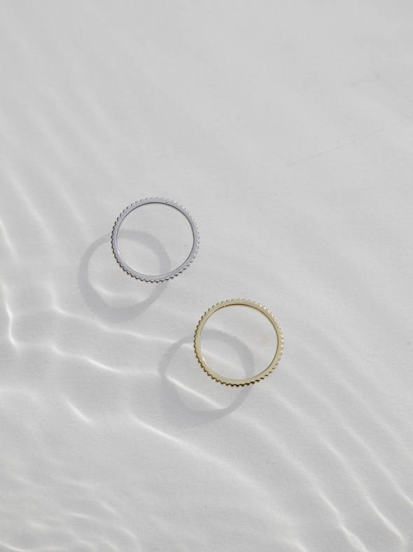 A gold and silver lines ring in water