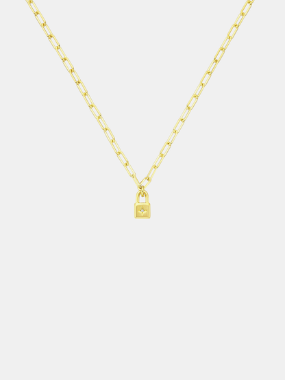 Gold necklace with a lock-shaped pendant on a light gray background