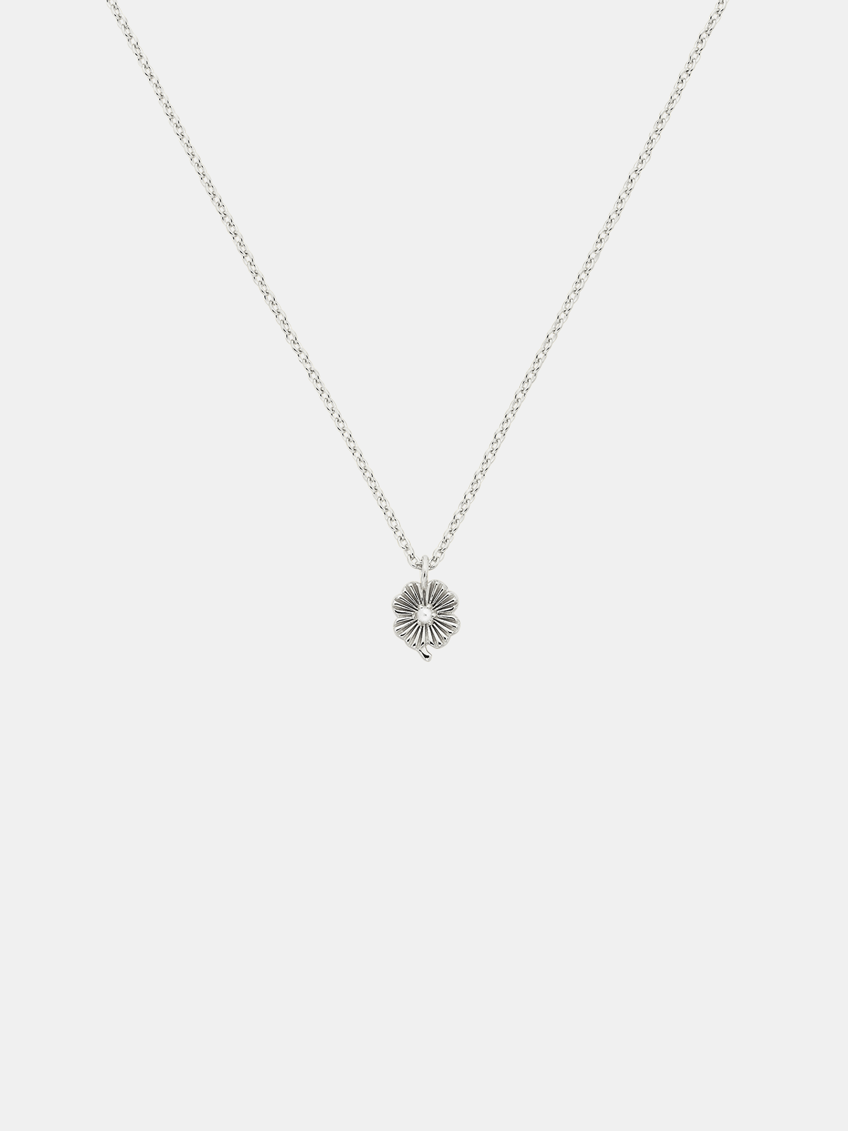 Silver necklace with a lily  pendant with small pearl on a light gray background