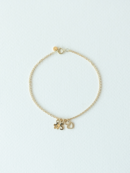 Mix It Up solid gold charm bracelet on a cable chain on a light blue background