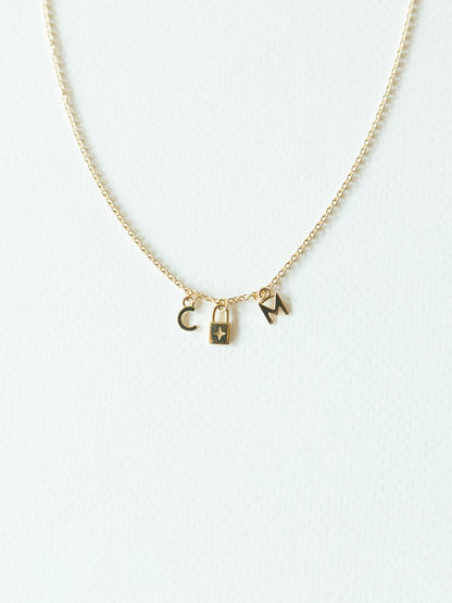 Solid gold mix it up necklace on cable chain with three small pendants on a white background