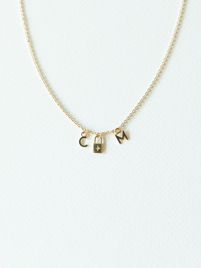 Solid gold mix it up necklace on cable chain with three small pendants on a white background