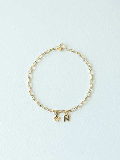Mix It Up solid gold charm bracelet on a mini links chain on a light blue background