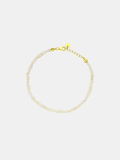 Pearl bracelet with gold clasp on a light gray background