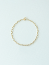 Gold chain bracelet on a light blue background