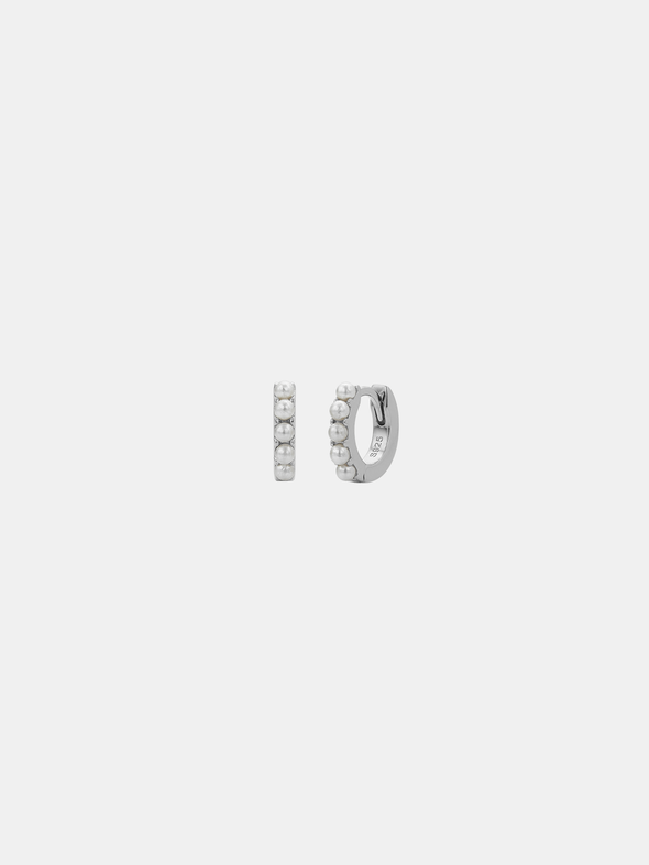 Silver hoop earrings with mini pearls on a light gray background