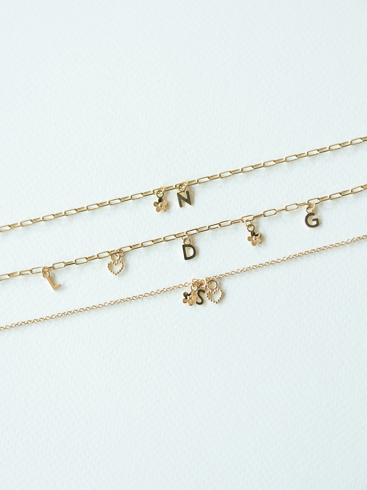 Mix It Up solid gold charm bracelets on a variety of chains