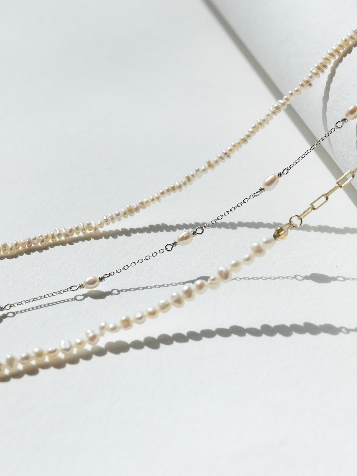 Set of layered pearl necklaces on a light background