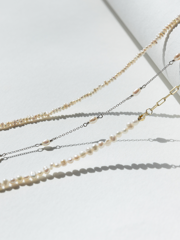 Set of layered pearl necklaces on a light background