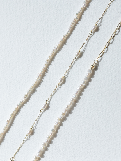 Three varying SOPHIE Store pearl bracelets on a white background
